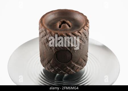 Unusual brown ceramic hookah bowl on a white background. Stock Photo