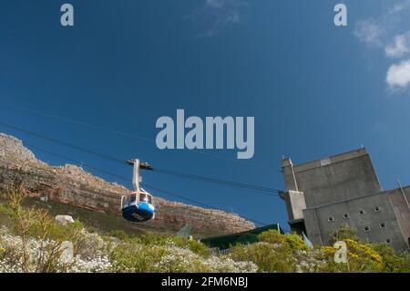 A cable car goes up the mountain at Table Mountain in Cape Town, South Africa. Table Mountain is a flat-topped mountain forming a prominent landmark o Stock Photo