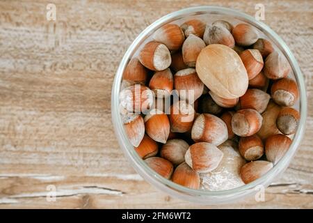 Hazelnuts in a glass cup on a wooden background. A rich source of vegetable fats. Stock Photo
