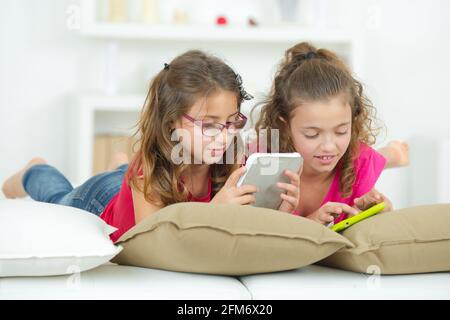 two sisters are using tablet and phone Stock Photo