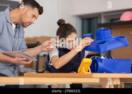 carpenter sharing wisdom with younger aspiring woman colleague Stock Photo