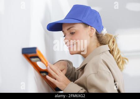 portrait of happy young woman holding builders level Stock Photo