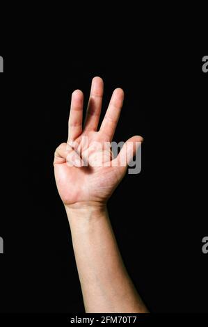 Hand making and showing Number 4 on a dark background Stock Photo
