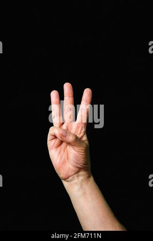 Hand making and showing Letter W International sign language dark background International sign language dark background Stock Photo