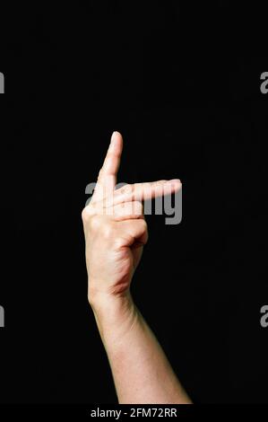 Hand making and showing Letter K International sign language dark background Stock Photo