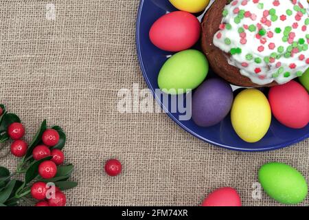 Plate with colorful Easter eggs, Easter cake and red berries. Stock Photo