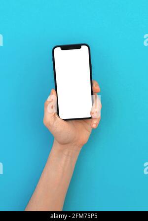 Kharkov, Ukraine - May 5, 2021: Man holds Apple iPhone with blank white screen mockup on a colorful pastel background Stock Photo
