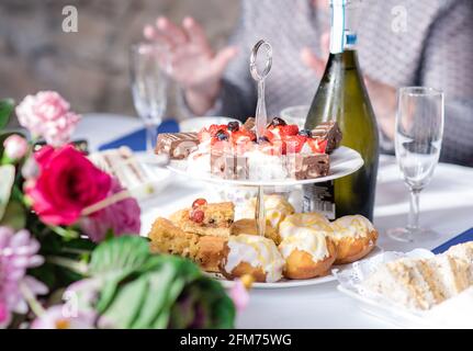 Afternoon tea buffet on cake stand with wine and scones Stock Photo