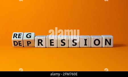 Depression or regression symbol. Turned cubes and changed the word 'depression' to 'regression'. Beautiful orange background. Psychological, depressio Stock Photo