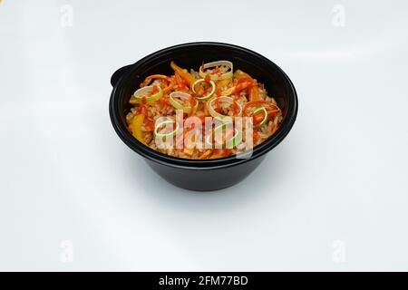 hot Italian macaroni in a disposable dish for food delivery, high-calorie fast food pasta on a white background Stock Photo