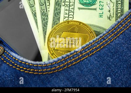 Dash coin in pocket with US dollar banknotes close-up view, crypto currency coin, investment concept Stock Photo