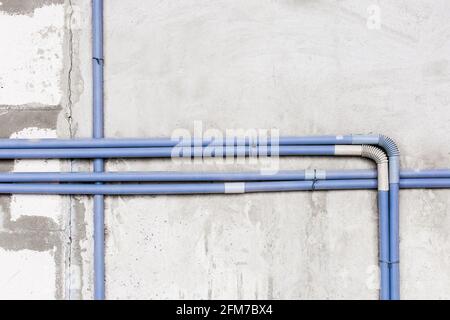 Plastic PVC pipe insulation on construction concrete home wall repair. Stock Photo