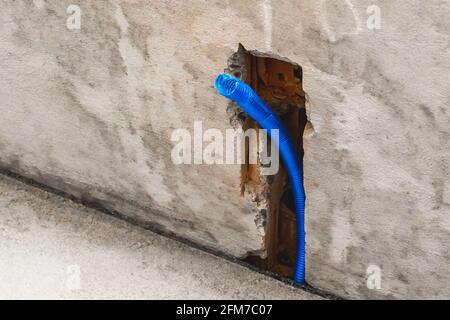 Plastic PVC pipe insulation material on construction concrete home wall repair. Stock Photo