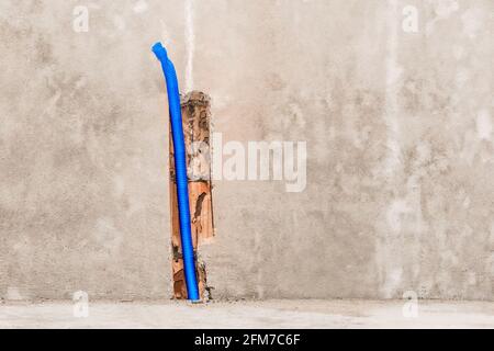 Plastic PVC pipe insulation material on construction concrete home wall repair. Stock Photo