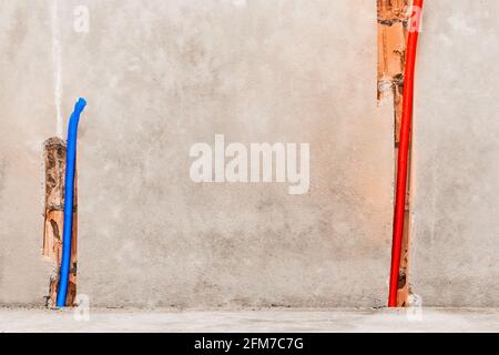 Plastic PVC pipe insulation material on construction concrete home wall repair. Stock Photo