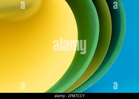 Abstract colored macro background, created with curved yellow, green and blue color paper sheets. Curved lines and shapes and soft vivid colors. Stock Photo