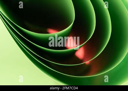 Abstract colored macro background, created with curved green and pink paper sheets. Curved lines and shapes and soft vivid colors. Stock Photo