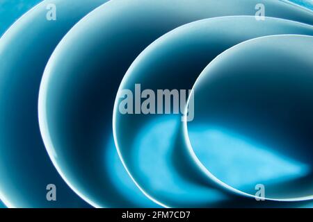 Abstract colored macro background, created with curved blue paper sheets. Curved lines and shapes and soft colors. Stock Photo