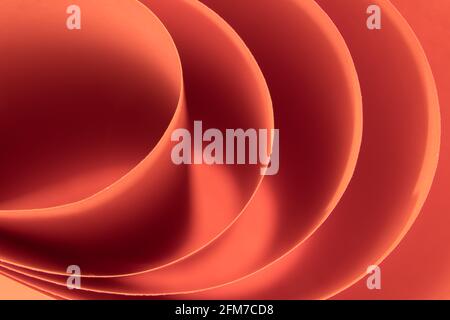 Abstract colored macro background, created with curved red paper sheets. Curved lines and shapes and soft vivid colors. Stock Photo