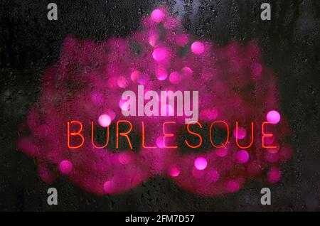 Vintage Neon Burlesque Sign in Wet Window Stock Photo