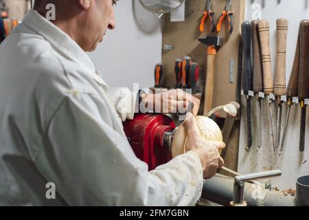 Cabinetmaker in his workshop placing a piece of wood on the lathe Stock Photo