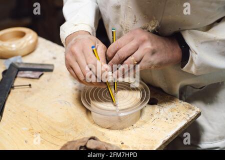 Woodworker marking a piece of wood with a pencil in his workshop Stock Photo