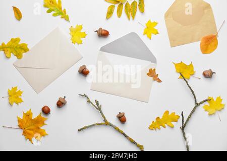 Envelopes and autumn leaves on white background Stock Photo