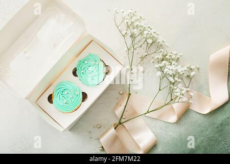 Composition with tasty cupcakes and flowers on color background Stock Photo