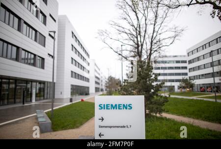 PRODUCTION - 30 April 2021, Bavaria, Erlangen: The lettering logo of the German industrial corporation Siemens, stands on a stele on the Siemens Campus Erlangen. Office and administrative workplaces as well as the research and development of Siemens in the region are concentrated on the campus, but the Friedrich-Alexander University Erlangen-Nuremberg (FAU) or Framatome (nuclear technology) are also represented there. The part that has already been completed, Module 1, is home to Siemens Mobility, Siemens Global Business Services, the Siemens CFO, the Siemens Central Franconia branch and Sieme Stock Photo