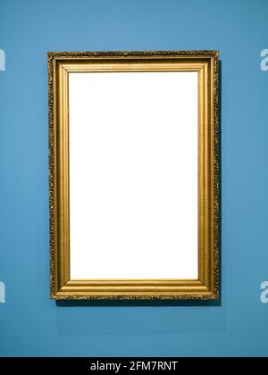 vertical golden wooden picture frame with cutout canvas on vertical blue wall Stock Photo