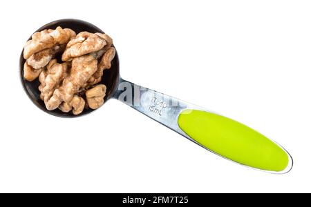top view of peeled walnuts in measuring spoon cutout on white background Stock Photo