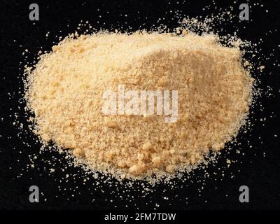 handful of granulated Coconut sugar closeup on black plate Stock Photo
