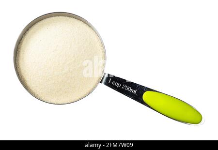 top view of raw manna croup (semolina from soft wheat) in measuring cup cutout on white background Stock Photo