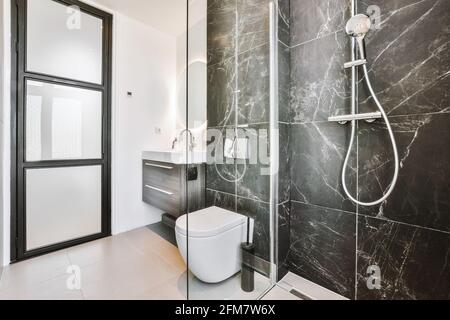 Interior of modern bathroom with black tile walls Stock Photo