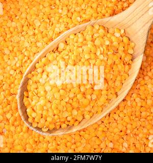 top view of split red lentils in wooden spoon closeup Stock Photo
