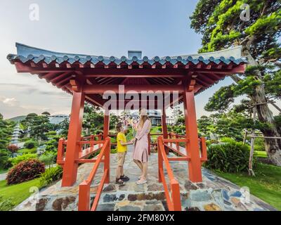 Mother and son travelers in medical mask looking at the Japanese traditional building. Tourists travel in Japan after the coronavirus epidemic Stock Photo