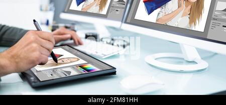 Designer And Photographer Using Multiple Computer Screens Stock Photo