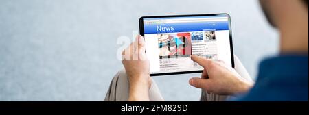 Reading Newspaper Article Online On Digital Tablet Stock Photo