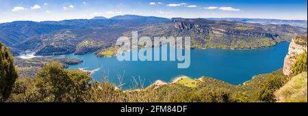 Great aerial panorama of the Sau reservoir overlooking a large part of the reservoir, with the Munts cliffs and the Montseny mountain range in the bac Stock Photo