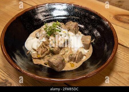 A delicious bowl of creamy Beef Stroganoff on a wooden kitchen Stock Photo