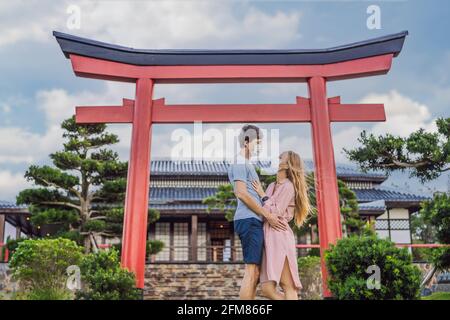 Happy couple travelers in medical mask looking at the Japanese traditional building. Tourists travel in Japan after the coronavirus epidemic Stock Photo