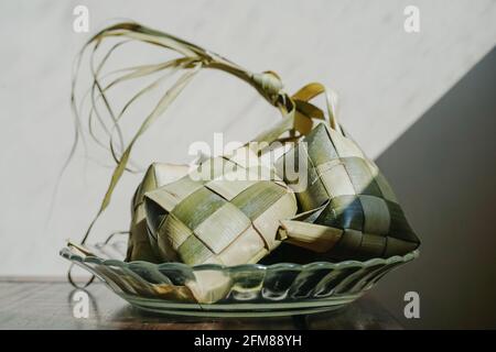 Ketupat is a rice cake wrapped with woven of coconut leaves that usually served when Eid al-Fitr Stock Photo