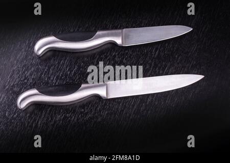 two Kitchen knifes on black wooden table Stock Photo