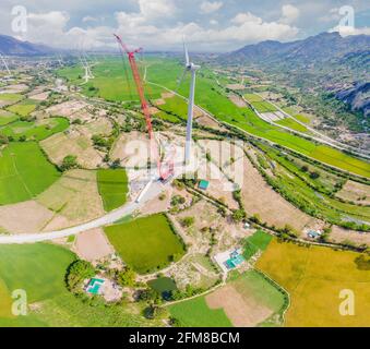 Wind turbine being repaired, assisted by crane and elevator. Wind power plant. green meadow with Wind turbines generating electricity Stock Photo