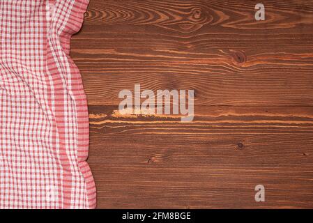 Checkered tablecloth or cloth napkin on wooden table with space for text, ideas. Top view Stock Photo