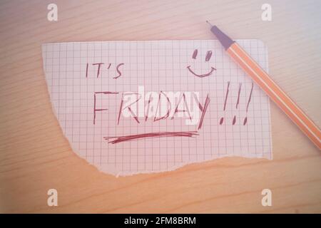 It's Friday! handwritten on a paper with light effects. Concept of joy for the upcoming weekend Stock Photo