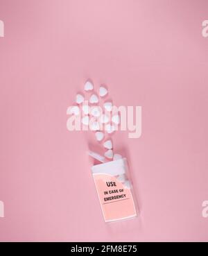 Box with use in emergency writing. Small white hearts coming out. On soft pink background. Minimal abstract Valentines, Mother's day concept. Stock Photo