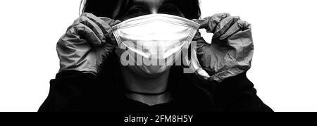 Black and White portrait of a young woman wearing the surgical mask correctly to protect herself from the Corona Virus Stock Photo