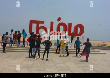 Visitors to Chennai Marina beach  enjoy the cool evening sea breeze talking selfie photograph at Namma Chennai landmark Stock Photo