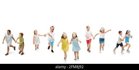 Group of happy school kids or pupils running in colorful casual clothes on white studio background. Creative collage. Stock Photo